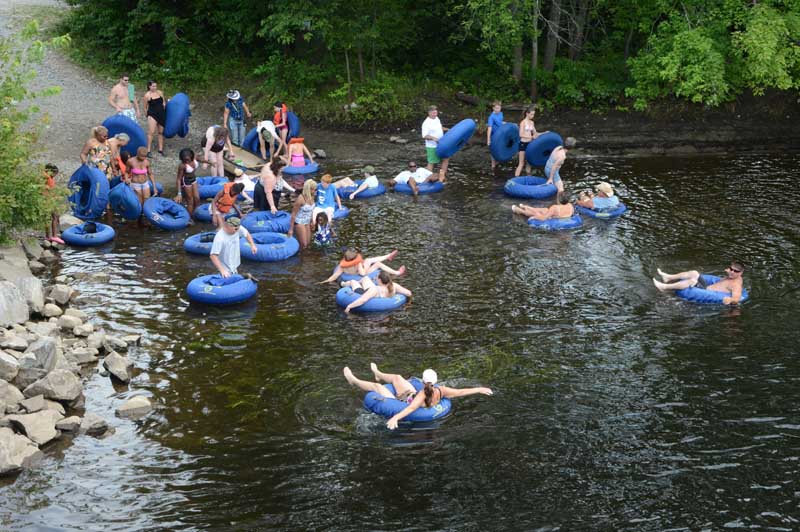 Group of people getting in the Schroon River for an afternoon of tubing